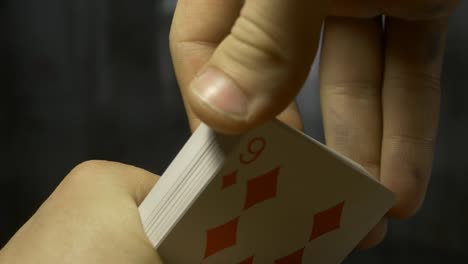 hands-holding-shuffle-playing-card-deck-on-wooden-table