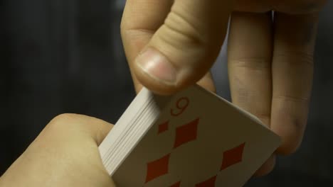 Hände-halten-Stapel-Spielkarten-auf-Holztisch