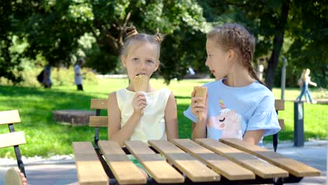 Chicas-comiendo-helado-al-aire-libre-en-verano-en-la-cafetería-al-aire-libre