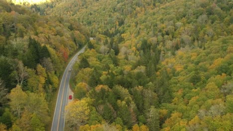 Aerial-Drone-view-of-Car-driving-in-Fall-/-Autumn-leaf-foliage-on-a-High-Mountain-road.--Vibrant-yellow,-orange,-and-red-colors-in-Asheville,-NC-in-the-Blue-ridge-Mountains.