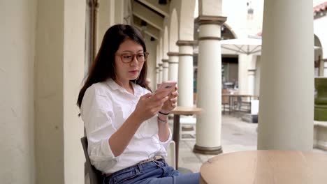 Frau-in-Café-chillen-und-überprüft-Telefon.