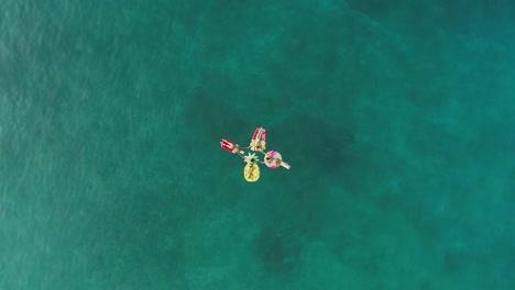 Aerial-view-group-of-women-holding-hands-on-inflatable-mattress-on-Atokos.