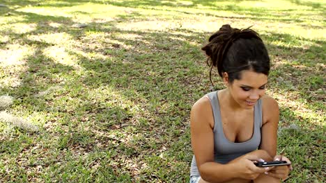 Young-woman-text-messaging-in-the-park