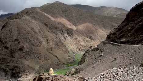 Two-Moroccan-women-dressed-in-traditional-gowns-sitting-on-an-edge-of-a-cliff