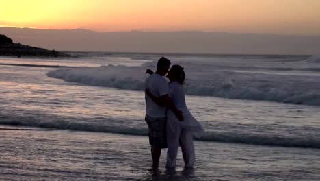 Paar-genießen-einen-romantischen-Umarmung-am-Strand-silhouette,-Südafrika