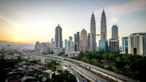 4-k-timelapse-vídeos-de-hermosa-puesta-de-sol-en-el-centro-de-la-ciudad-de-Kuala-Lumpur-desde-el-último-piso-del-hotel,-con-vista-panorámica-a-la-ciudad,-la-autopista,-y-ráfaga-de-luz-del-sol.-Zoom-in-y-pan-a-la-izquierda.