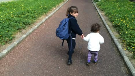 Young-sister-walks-with-her-older-sister-to-school