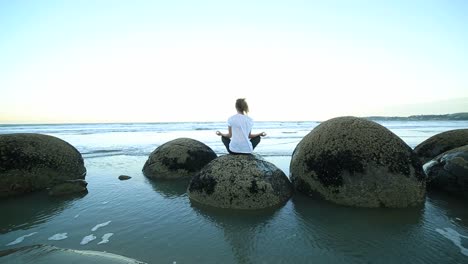 Female-holding-the-lotus-position-yoga-on-boulder