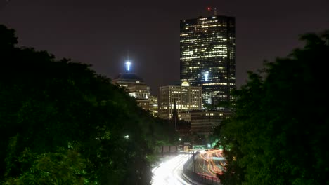 Boston-Verkehr-in-der-Nacht-Zeitraffer.--Belebten-Stadt-Bewegung-entlang-dem-Storrow-Drive,-Blick-auf-die-Hochhäuser-Downtown.