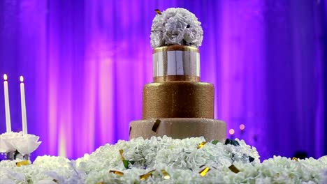 Hochzeitstorte,-dekoriert-mit-Blumen-bei-trauung