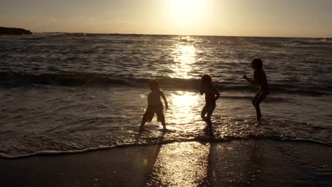 Tres-niños-jugando-en-la-playa-juntos