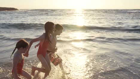 Drei-Kinder-spielen-am-Strand-zusammen