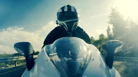 Tiro-POv-de-un-hombre-montado-en-una-motocicleta-de-deportivo-de-color-blanco-en-una-carretera-de-curva