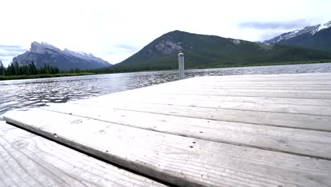 Woman's-feet-walking-on-jetty-above-lake,-Canada