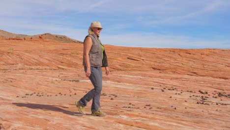 Turismo-de-senderismo-en-el-desierto-mujer-caminando-en-el-Parque-roca-roja-lenta-4K