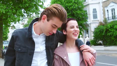 Stylish-Young-Couple-Walking-Along-City-Street-Together