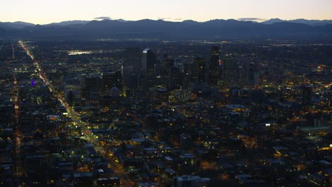 Vista-aérea-de-Denver-en-la-noche-con-montañas-rocosas-en-el-fondo