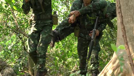 Soldat-Pistole-Waffe-und-Rüstung-mit-Rauch-gleichmäßig-sein.-Soldaten-nehmen-die-Verwundeten-aus-dem-Dschungel.