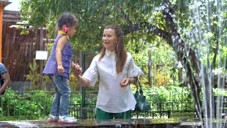 Mom-and-daughter-are-walking-by-the-fountain.