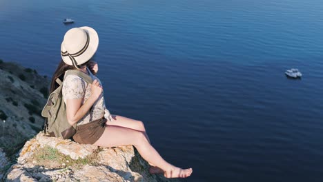 Hohen-Winkel-verspielt-Rucksack-barfuß-Frau-in-Hut,-die-Aussicht-auf-Bucht-und-seelandschaft