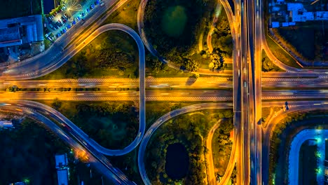 Lapso-de-tiempo-de-la-vista-superior-vista-aérea-de-la-autopista,-autopista-y-carretera-en-el-detalle-de-cruce-en-la-noche