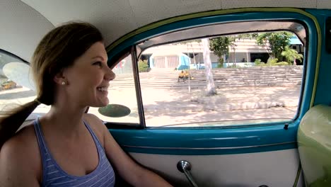 Tourist-woman-riding-in-a-Classic-Ford-car-taxi-in-Havana-Cuba