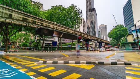 Zeitraffer-der-typischen-Straßenverkehr-Kreuzung-in-regnerischen-Tag-4K,-Malaysia