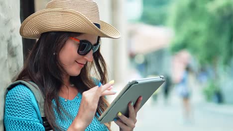 Portrait-of-beautiful-lost-female-tourist-standing-using-tablet-PC-in-summer-European-city