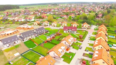 Camera-flight-over-new-family-houses-and-construction-site-in-suburban-district.-Construction-industry-and-economic-growth-in-European-Union.