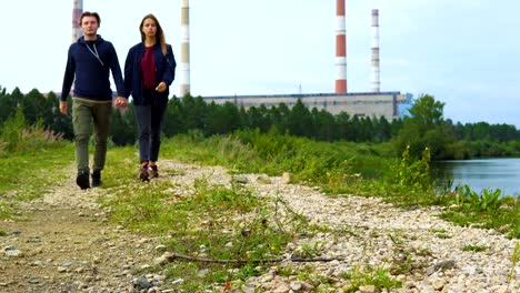 A-young-man-and-a-girl-are-walking-along-the-path-along-the-river.