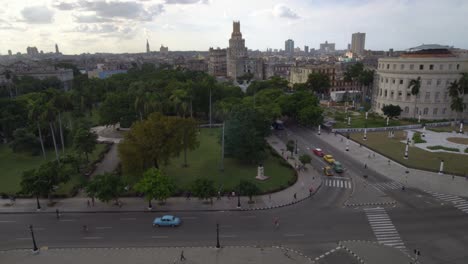 Old-classic-American-car-turning-on-street-next-to-capitol,-in-Havana,-Cuba