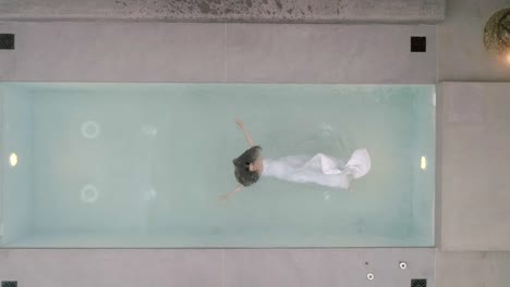 Aerial-view-of-a-woman-falling-in-the-water-using-a-wedding-dress,-Greece.