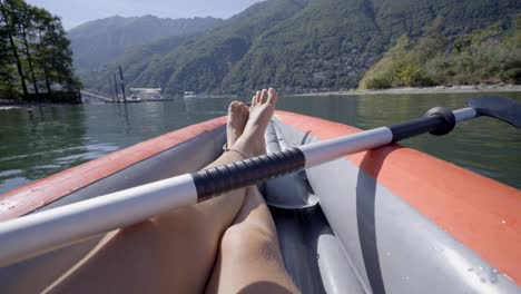 Personal-perspective-of-woman-on-red-canoe-paddling-on-beautiful-lake-in-summer-enjoying-outdoor-activities.-Point-of-view-of-person-canoeing-in-Switzerland.-4K-video