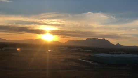 Flug-mit-Sonnenuntergang-im-Hintergrund-über-den-Tafelberg-in-Kapstadt-ankommen