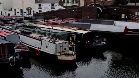 Wide-High-Angle-Pan-of-Narrow-Boats-Docked-in-Canal-Harbor