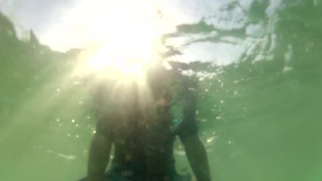 UNDERWATER:-Young-surfer-waiting-for-a-wave