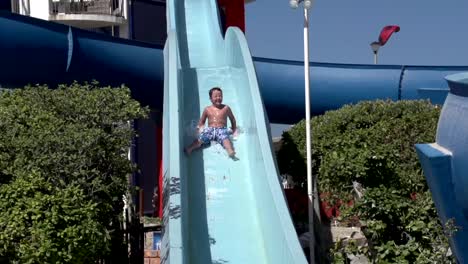 Cámara-lenta-de-niño-feliz-en-tobogán-de-agua,-Sudáfrica