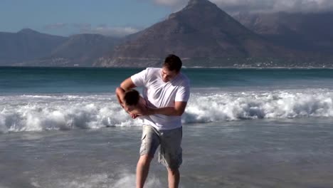 Couple-with-child-playing-in-the-waves,-Cape-Town