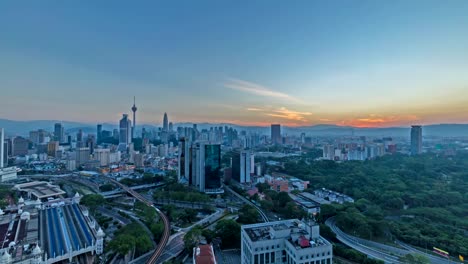4k-footage-time-lapse-of-beautiful-sunrise-at-Kuala-Lumpur-city-centre-from-a-rooftop-of-a-building,-with-city-skyline,-train,-and-burst-sunlight.
