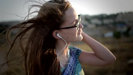 Adolescente-Chica-con-gafas-escucha-la-música-al-aire-libre