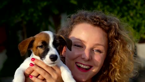 Bella-mujer-besando-a-lindo-cachorro-al-aire-libre