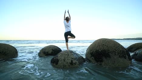 Mujer-de-ejercicios-de-Yoga-en-Boulder-en-el-mar