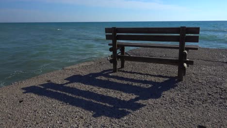 Eine-einsame-Bank-auf-dem-Pier-in-der-Nähe-des-Meeres-in-einem-Strand-in-Griechenland