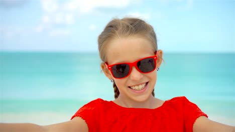 Kleines-Mädchen-unter-Selfie-Porträt-mit-ihrem-Smartphone-am-Strand