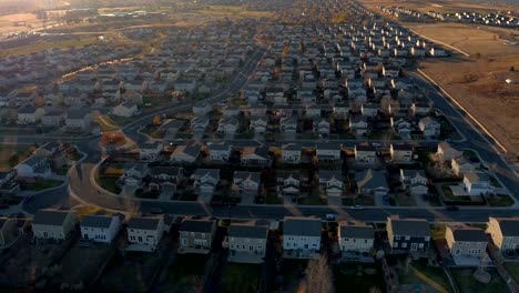 ANTENA:-Casas-nuevas-en-pueblo-suburbano-moderno-al-amanecer-soleado-en-Denver,-Estados-Unidos