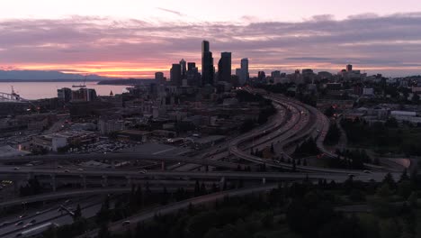 Hyperlapse-aérea-de-puesta-de-sol-en-el-centro-de-Seattle-horizonte-con-la-ciudad-en-movimiento,-moviéndose-a-alta-velocidad