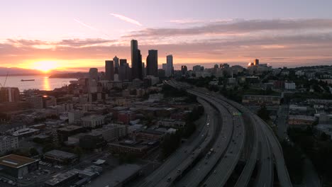 Hubschrauber-Luftaufnahmen-der-Skyline-von-Seattle-mit-roten-Lens-Flare-von-glühenden-Sonnenuntergang