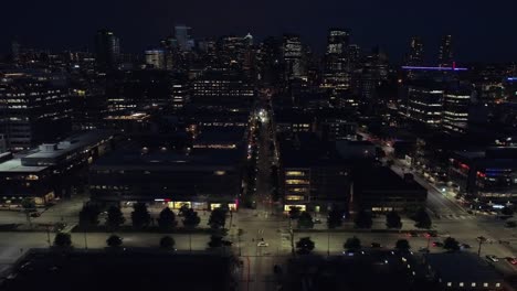 Stadtbild-Antenne-Dolly-in-dunklen-Nacht-mit-Citylights-der-Innenstadt-von-Gebäuden