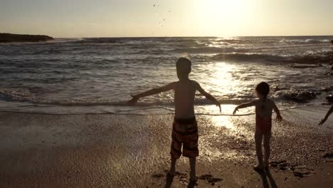 Tres-niños-jugando-en-la-playa-juntos