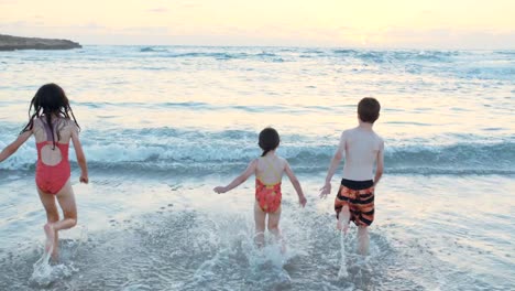 Drei-Kinder-spielen-am-Strand-zusammen